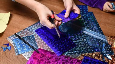 Anne ve çocuk hobi olarak parlak renkli kağıtlarla el sanatları yapıyor.