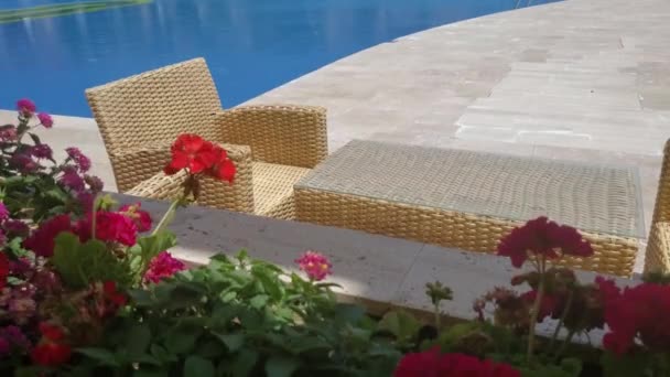 Zeezicht terras met rode geranium bloemen en rotan meubels met niemand — Stockvideo