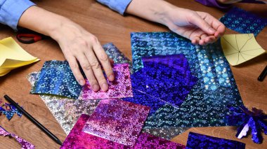 Kadın eli hobisi. Parlayan renkli kağıtlarla el işi.