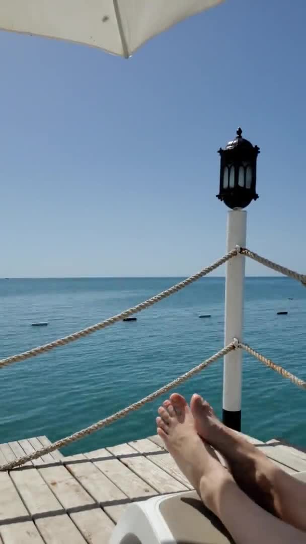 Time lapse pieds nus sur chaise longue à quai bord de mer avec lanterne vintage — Video