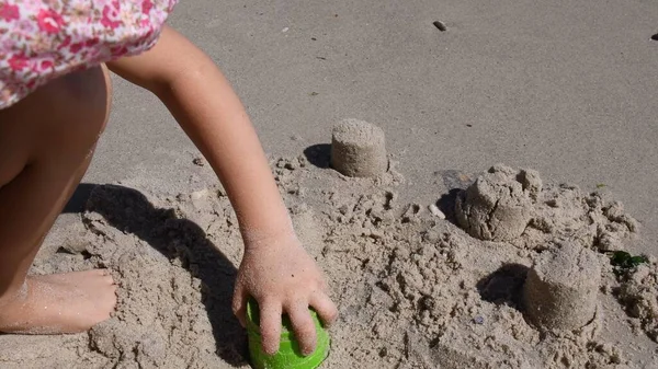 Kind bastelt Sandburg mit Sandschimmelwerkzeug am Strand — Stockfoto