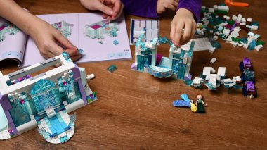Bebeklerin ve annelerin elleri Lego oyuncakları oynar.