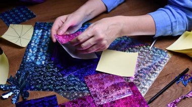 Kadın eli hobisi. Parlayan renkli kağıtlarla el işi.