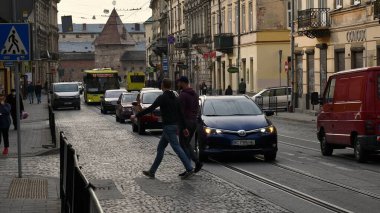 Kalabalık trafiği olan eski Lviv şehir sokağından geçenler