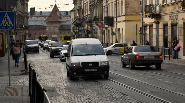 Cars driving by old Lviv city street with busy traffic