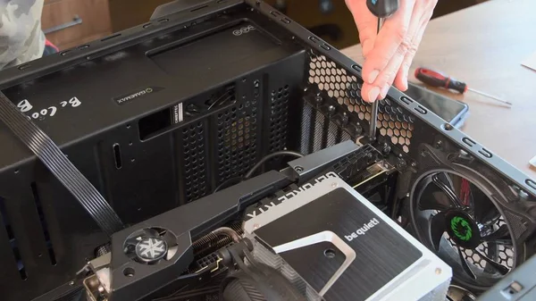 Mãos de homem com chave de fenda montar refrigerador CPU com placa gráfica NVidia GeForce instalado no interior — Fotografia de Stock