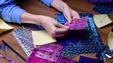 Kadın eli hobisi. Parlayan renkli kağıtlarla el işi.