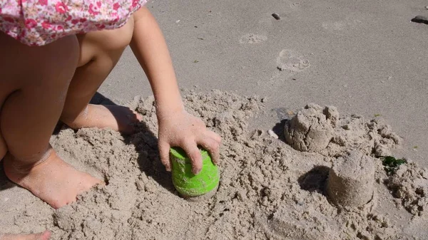 Дитина робить пісочний замок з інструментом для піщаної форми на пляжі — стокове фото