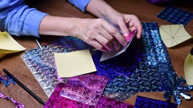 Kadın eli hobisi. Parlayan renkli kağıtlarla el işi.