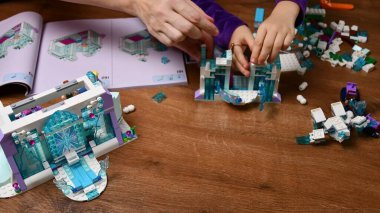 Kadın ve çocuğun elleri Lego blokları ve oyuncak tuğlalar oynuyor