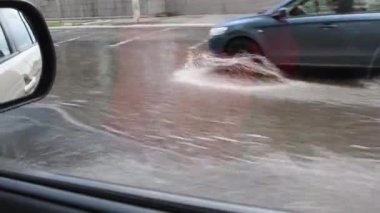 Kirli su akışı ile şehir trafiği ile dolu su basmış yola araba penceresinden bak