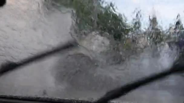 Вітрове скло автомобіля вид міського руху затопленою вулицею. — стокове відео