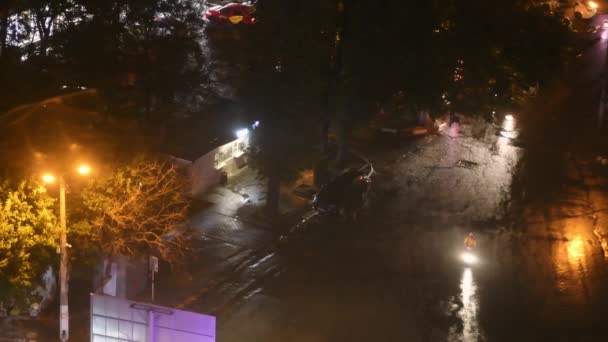 Nocny widok na miasto po deszczu z rozmazanych świateł ulicznych i rzadkich samochodów przejeżdżających przez — Wideo stockowe