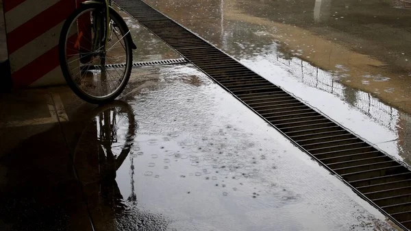 Szitált eső cementes talajon városi parkoló kerékpárral — Stock Fotó