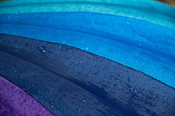 Raindrops on blue purple shades umbrella closeup wet fabric texture — Stock Photo, Image