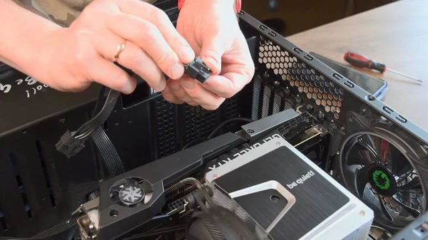 As mãos do homem montam e instalam o refrigerador da CPU e a placa gráfica NVidia GeForce — Fotografia de Stock