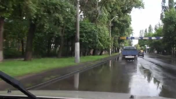 Su basmış caddedeki şehir trafiğinin araba ön camı görüntüsü — Stok video