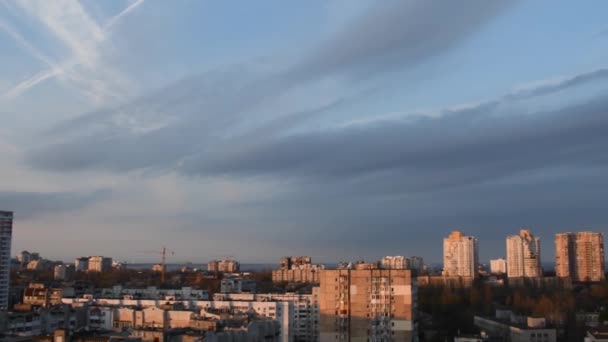 Grey spindrift clouds in blue sky over cityscape in golden hour of sunset — Stock videók