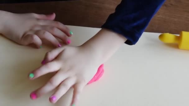 Χέρια του μικρού κοριτσιού 3-5 ετών που παίζουν πολύχρωμο παιχνίδι ζύμης με πλαστικό μαχαίρι μοντελοποίησης — Αρχείο Βίντεο