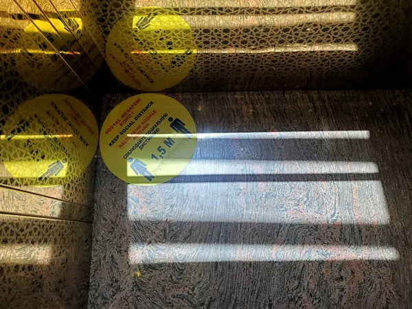 터키어 독일어 러시아어에서 사회적 거리를 경고하는 노란색 스티커가 대리석 바닥에는 — 스톡 사진