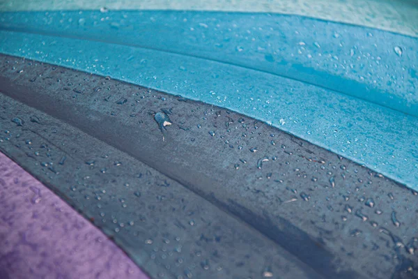 Raindrops on grey blue shades umbrella closeup wet fabric texture — Stock Photo, Image