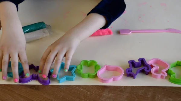 Toddler руки касаются пластиковых форм для теста — стоковое фото