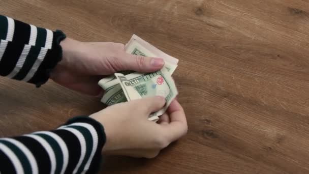 Las manos femeninas cuentan billetes de dólar e inspeccionan para encontrar billetes no aptos — Vídeo de stock