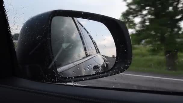 Vue floue dans le rétroviseur latéral de la voiture en mouvement rapide par temps pluvieux — Video