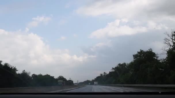 Verre à brouillard de pare-brise avec gouttes de pluie tombant tout en conduisant rapidement par la route — Video