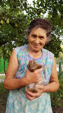 Çiftlik bahçesinde evcil tavşanı olan 80 'lerin büyükannesi.