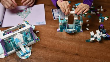 Kadın ve çocuğun elleri Lego blokları ve oyuncak tuğlalar oynuyor