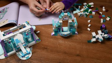 Kadın ve çocuğun elleri Lego blokları ve oyuncak tuğlalar oynuyor