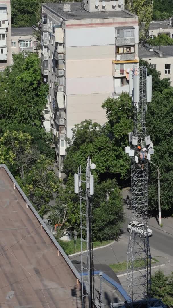 Неузнаваемый строитель на крыше здания с коммуникационной башней — стоковое видео