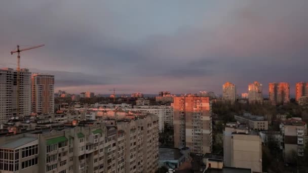 Purple clouds in grey sky over cityscape in golden hour of sunset — Stock Video