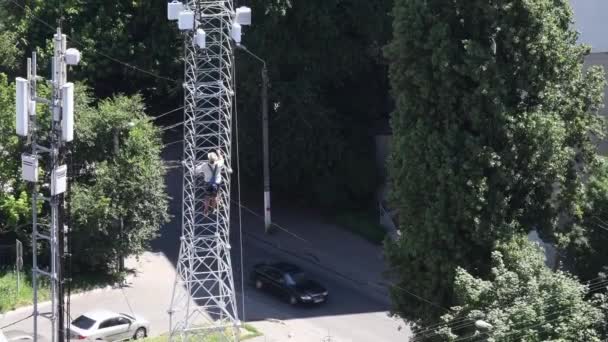 Operaio edile alpinista sale in cima alla torre di comunicazione — Video Stock