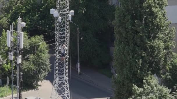 Pekerja konstruksi Mountaineer naik ke atas menara komunikasi — Stok Video