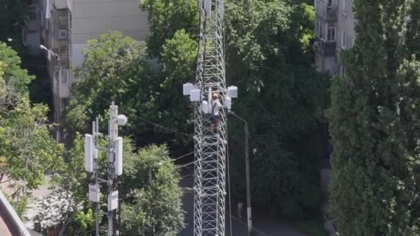 Operaio edile alpinista scende dalla cima della torre di comunicazione — Video Stock