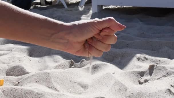 Femmina mano rovescia sabbia spiaggia da manciata — Video Stock