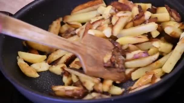 在厨房的炉灶上把自制的炸薯条放在锅里烤和搅拌 — 图库视频影像