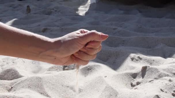 Kobieta rozlewa piasek na plaży z garści — Wideo stockowe