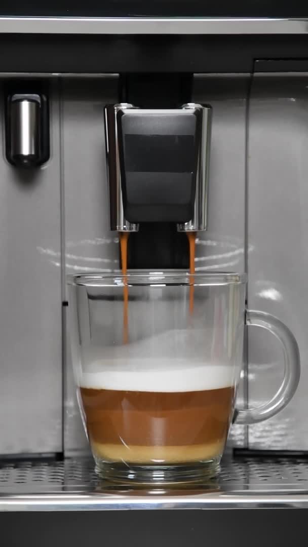 Coffee maker pouring hot espresso to prepare coffee with milk — Stock Video