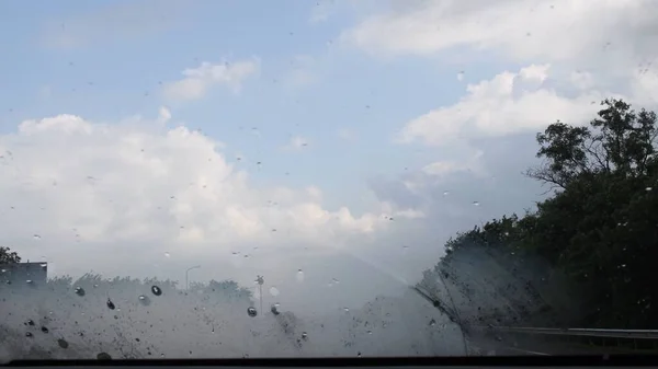 Verre à brouillard de pare-brise avec gouttes de pluie et fond flou — Photo