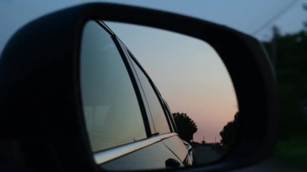Oldalsó tükör autó fényvisszaverődése vezetés autó alkonyatkor — Stock videók
