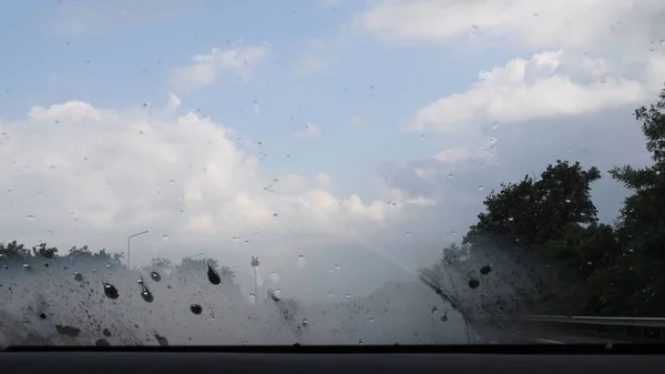 Vernebeltes Glas der Windschutzscheibe mit Regentropfen und verschwommenem Hintergrund — Stockfoto