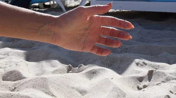 Mão feminina pele de palma cobrindo por grãos de areia de praia — Fotografia de Stock