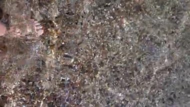 POV ayakları su altında çakıl taşı gibi suyun içinde yürüyor.