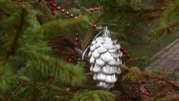 Adorno de Navidad retro colgando de la rama del árbol de coníferas y se balancea en el viento — Vídeo de stock