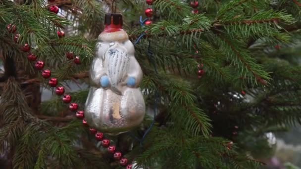 Винтажный рождественский орнамент висит на ветке хвойной елки и раскачивается на ветру — стоковое видео