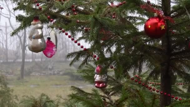 Bolitas vintage y bolas rojas de Navidad se balancean en las ramas del árbol de Navidad al aire libre — Vídeos de Stock