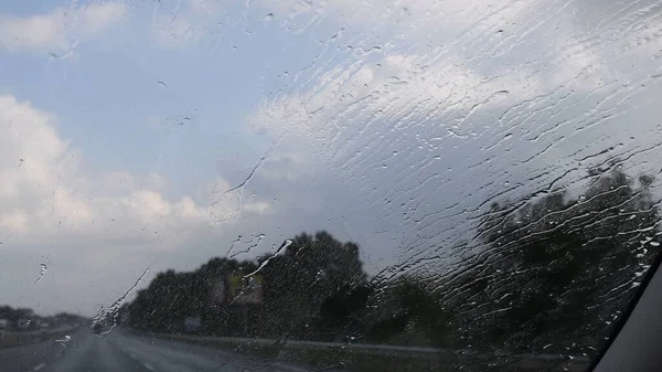 빗물 이 뚝뚝 떨어지고 떨어지는 자동차 앞 유리창 — 스톡 사진